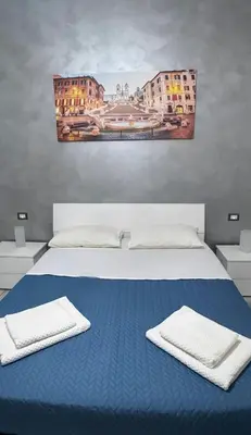 a bedroom with a blue bed with two towels on it at Cataldo Suites Roma in Rome