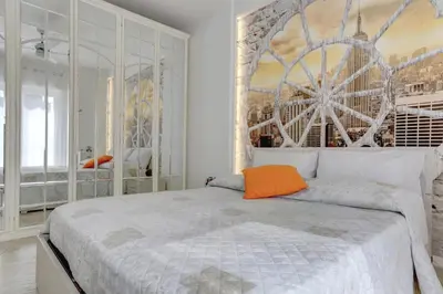 a bedroom with a large white bed with an orange pillow at Delizioso attico con terrazzo in Rome