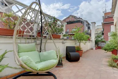 a hanging chair on a balcony with plants at Delizioso attico con terrazzo in Rome