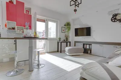 a bedroom with red cabinets and a kitchen with a table at Delizioso attico con terrazzo in Rome