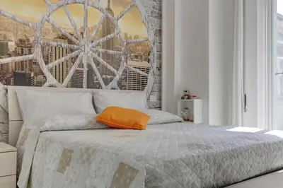 a bedroom with a bed with an orange pillow on it at Delizioso attico con terrazzo in Rome