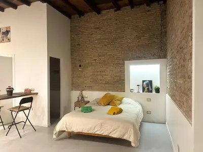 a bedroom with a bed and a brick wall at Veronica House in Rome