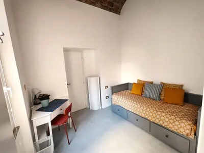 a bedroom with a bed and a desk and a table at Veronica House in Rome