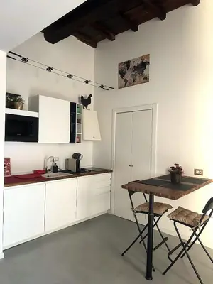 a kitchen with white cabinets and a wooden table at Veronica House in Rome