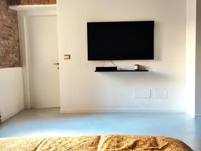 a living room with a television on a white wall at Veronica House in Rome