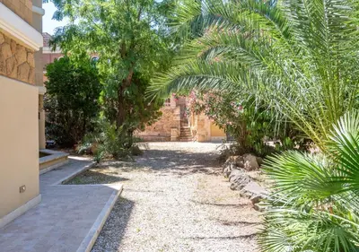 a garden with palm trees and a building at Domus Aventino Apartment in Rome