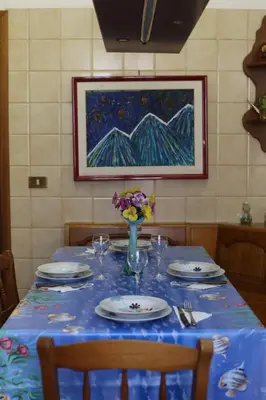 a table with a blue table cloth and plates and flowers at Artist's House Colosseum in Rome