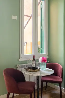 a table with a bottle of wine and two chairs at Rome Dreamer Suite in Rome