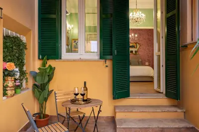 a room with green shutters and a table with wine glasses at Rome Dreamer Suite in Rome