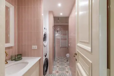 a bathroom with a sink and a washing machine at Rome Dreamer Suite in Rome