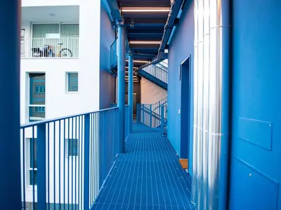 a hallway of an apartment building with blue stairs at Pop House Labicana in Rome