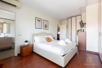 a bedroom with a white bed with two towels on it at Imperium Trastevere Flat - 4-6 pax, A-C, Panoramic view, 2 Baths in Rome