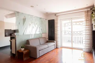 a living room with a couch and a window at Imperium Trastevere Flat - 4-6 pax, A-C, Panoramic view, 2 Baths in Rome