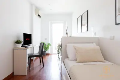 a bedroom with a bed and a desk with a television at Imperium Trastevere Flat - 4-6 pax, A-C, Panoramic view, 2 Baths in Rome