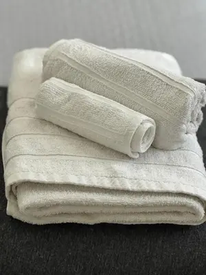 four white towels stacked on top of each other at La Casetta Monteverde in Rome
