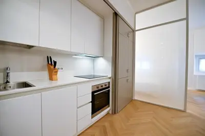 a kitchen with white cabinets and a sink and a stove at Dolce Vita Suite by Rental in Rome in Rome