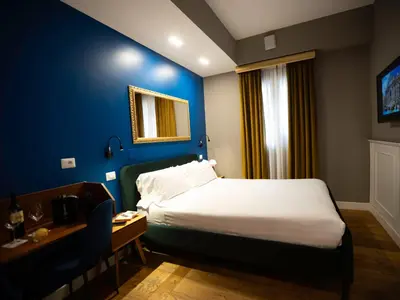 a hotel room with a bed and a desk and a window at Jb Relais Luxury in Rome