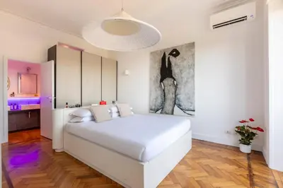 a white bedroom with a white bed and a painting at Casa Lea by Hili in Rome
