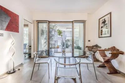 a dining room with a glass table and chairs at L'elegante Casa Di Anna - Roma EUR in Rome