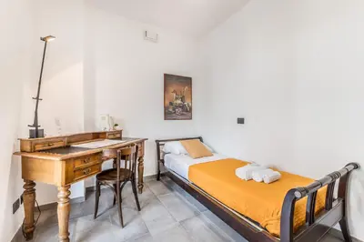 a bedroom with a desk and a bed and a desk and a bed at L'elegante Casa Di Anna - Roma EUR in Rome