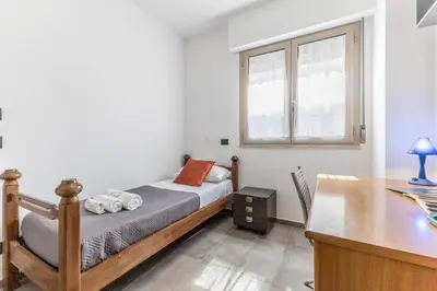 a small bedroom with a bed and a desk at L'elegante Casa Di Anna - Roma EUR in Rome