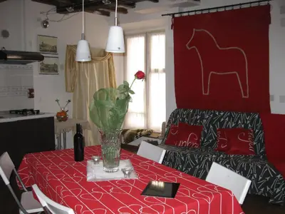 a table with a red table cloth with a horse on the wall at Musa Apartments in Rome