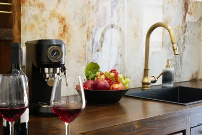 a glass of wine and a bowl of fruit on a counter at Barocci Home in Rome