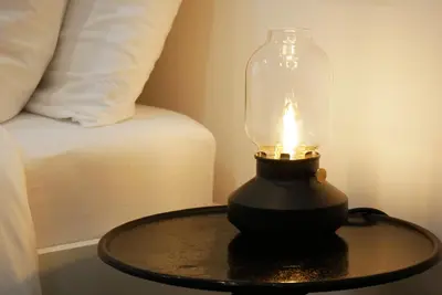 a lamp on a table next to a bed at Barocci Home in Rome