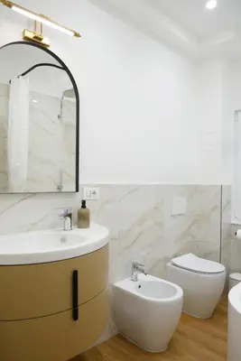 a bathroom with a sink and a toilet and a mirror at Barocci Home in Rome