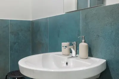 a white sink in a bathroom with green tiles at Conca D'Oro Guest House - Elisabetta in Rome