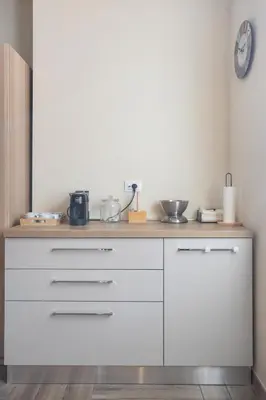 a kitchen counter with white cabinets and a clock on the wall at Conca D'Oro Guest House - Elisabetta in Rome