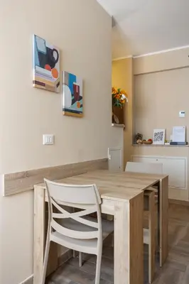 a dining room with a wooden table and a white chair at Conca D'Oro Guest House - Elisabetta in Rome