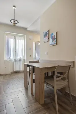 a dining room with a wooden table and a chair at Conca D'Oro Guest House - Elisabetta in Rome