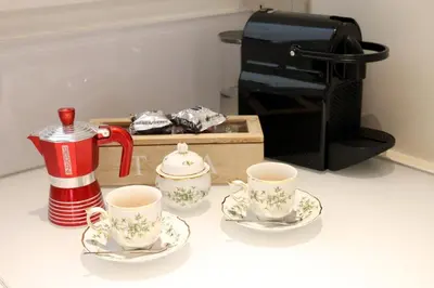 a table with two tea cups and a coffee maker at Independent house- Heart of Rome in Rome