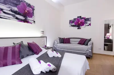 a bedroom with two beds with purple pillows at Gemme Di Roma Accomodation in Rome