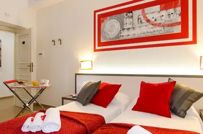 two beds in a room with red and white pillows at Gemme Di Roma Accomodation in Rome