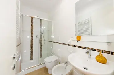 a white bathroom with a toilet and a sink at Gemme Di Roma Accomodation in Rome