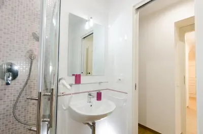 a white bathroom with a sink and a shower at Gemme Di Roma Accomodation in Rome