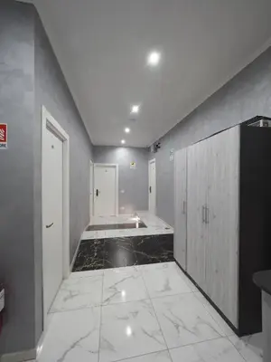 a large room with a hallway with white walls and marble floors at Casa Di David in Rome