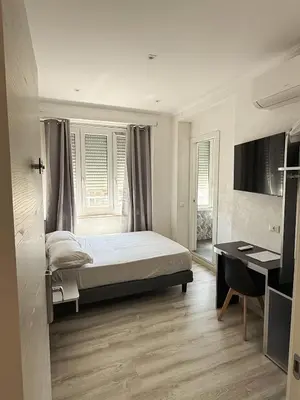 a bedroom with a bed and a desk in it at Isabel Rooms in Rome