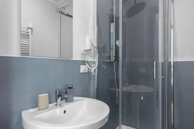 a bathroom with a sink and a glass shower at Conca D'Oro Guest House - Anna in Rome