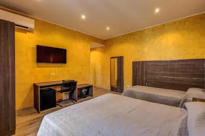 a bedroom with two beds and a flat screen tv at Osimar Rooms in Rome