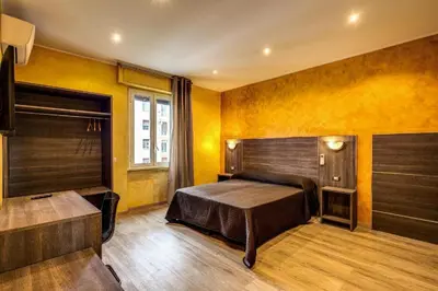 a bedroom with a bed and yellow walls at Osimar Rooms in Rome