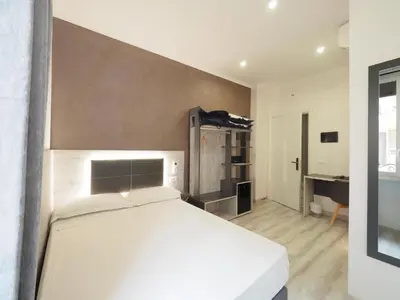 a bedroom with a white bed and a desk at Osimar Rooms in Rome