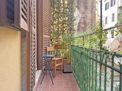 a small balcony with a table and chairs on a building at Monti - Colosseum - Boschetto Vintage - 2BR in Rome