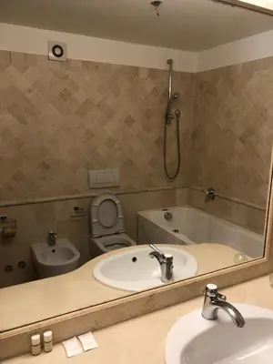 a bathroom with a sink and a toilet and a mirror at Charming Apartment in Trastevere in Rome