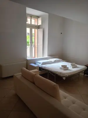 a room with a bed and a couch and a window at Charming Apartment in Trastevere in Rome
