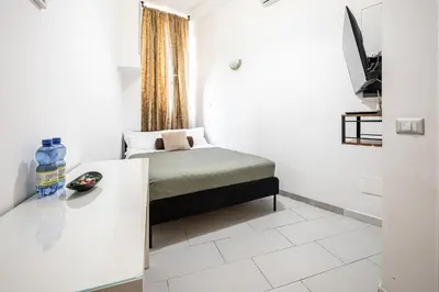 a small room with a bed and a table at Domus Lodi Urban Stay I Affittacamere in Rome