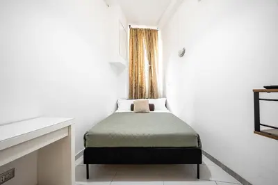 a small bedroom with a bed in a white room at Domus Lodi Urban Stay I Affittacamere in Rome