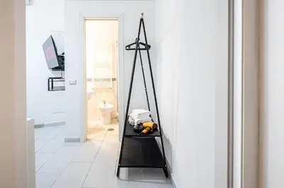 a room with a black shelf in a white room at Domus Lodi Urban Stay I Affittacamere in Rome
